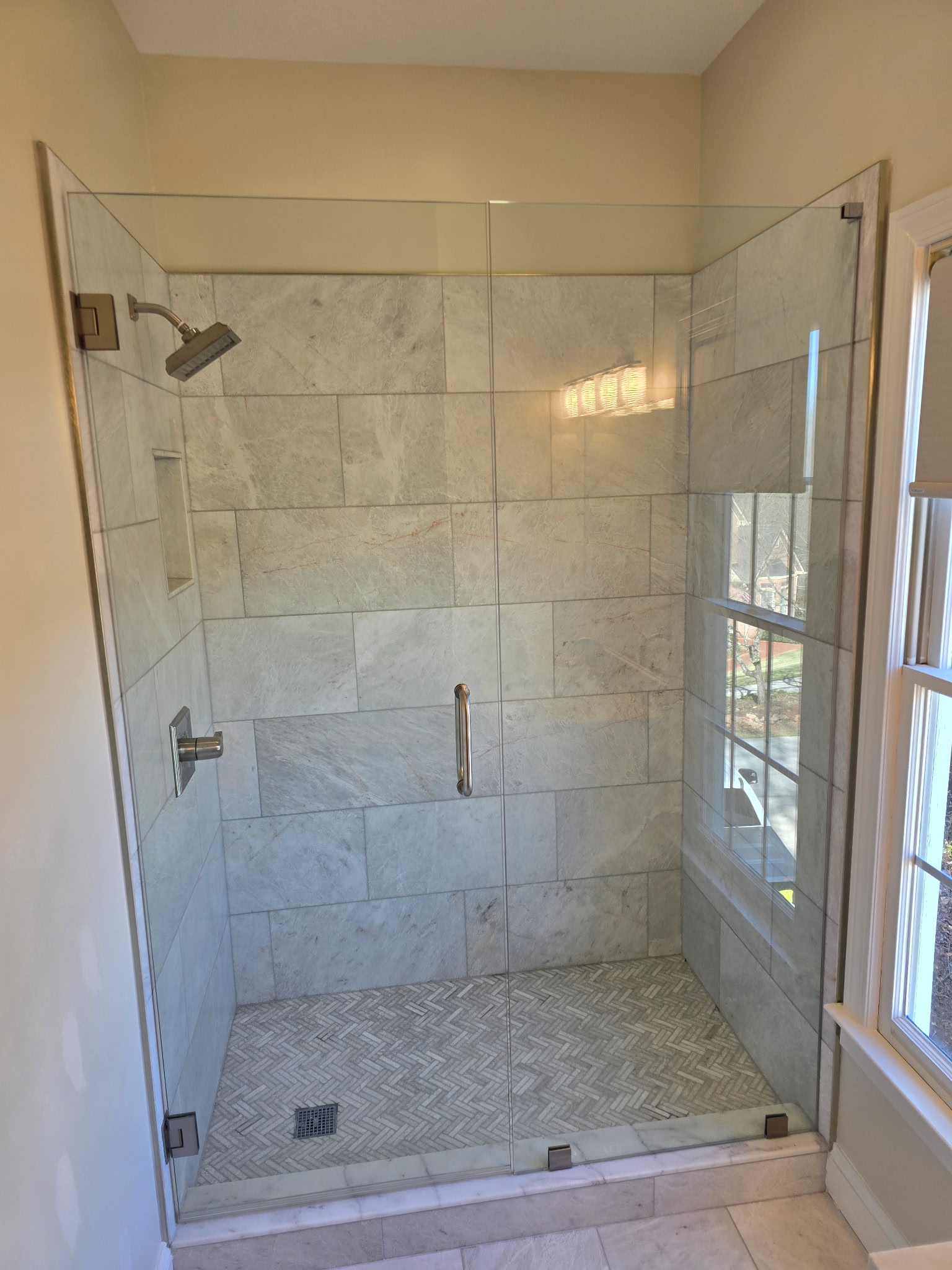 Custom marble shower with glass enclosure